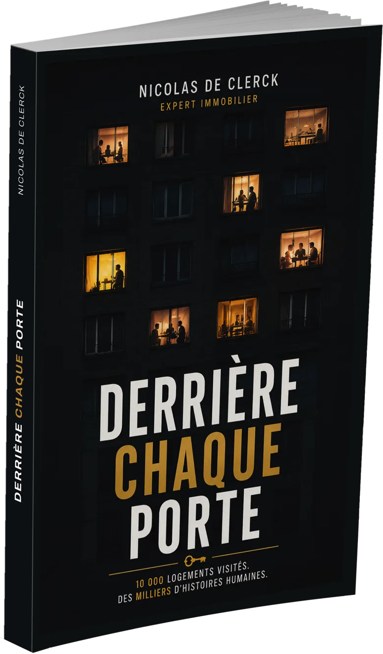 Le livre Derrière chaque porte de Nicolas De Clerck, expert immobilier, debout de trois quarts, dos et couverture visibles